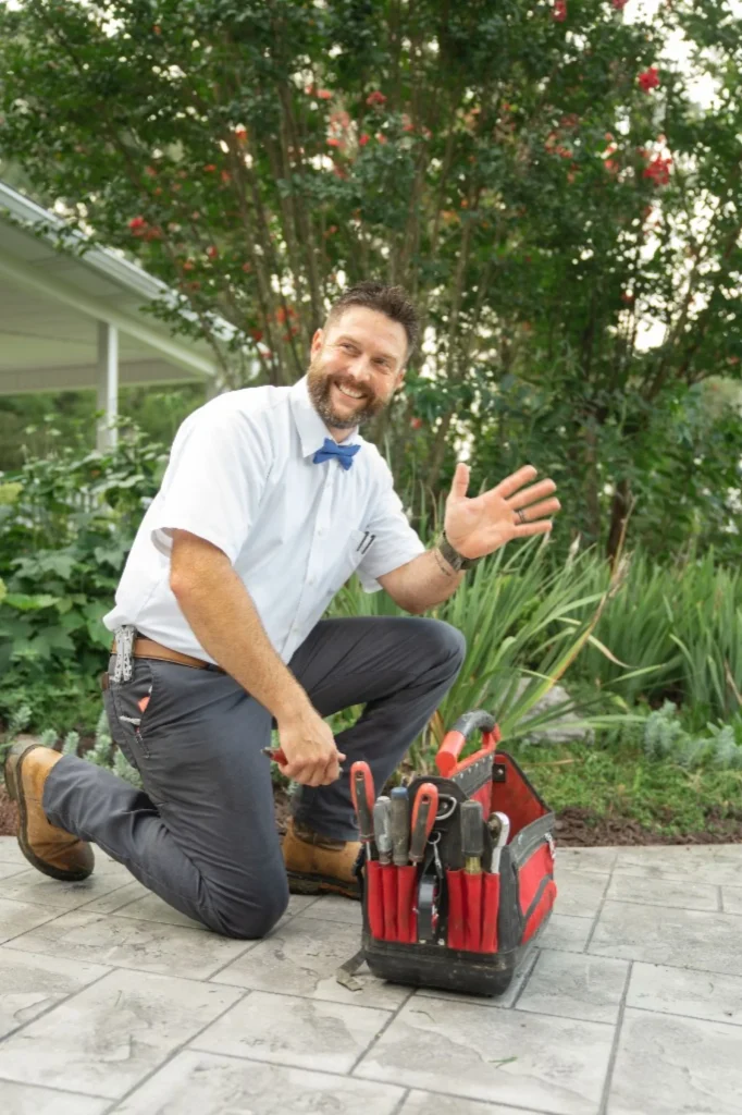 Mulberry Service Co. plumber waving beside a tool bag